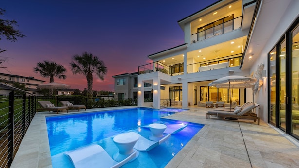 A modern house with a swimming pool, lounge chairs, and a balcony. - The Palm House at Reunion-TT484 (Kissimmee)