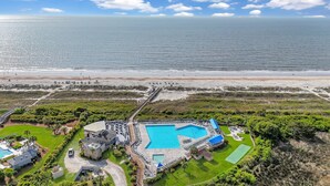 Un complexe hôtelier doté d’une grande piscine, d’un accès direct à la plage et d’une pelouse bien entretenue.