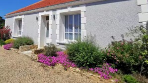 A white house with a red-tiled roof, surrounded by a garden with pink flowers and shrubs. - The Fleur de Sel - 6 people (Les Sables-d´Olonne)
