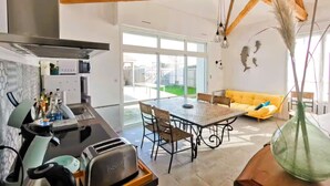 A modern kitchen with a dining area, a sofa, and a large window. - The Fleur de Sel - 6 people (Les Sables-d´Olonne)