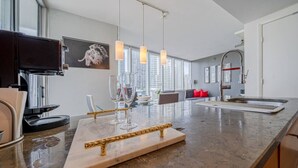 A modern kitchen with a marble countertop, a coffee machine, and a wine glass holder.