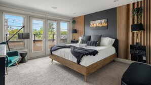 Une chambre à coucher moderne avec un grand lit, un bureau et une chaise.