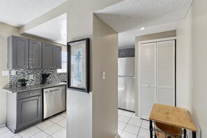 Enjoy cooking in this well-equipped kitchen with a stainless steel refrigerator, oven, and granite countertop.