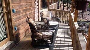 A wooden deck with wicker furniture and a pergola. - Cozy 4-bedroom cabin with AC, fitness room, WiFi in fantastic Modoc (Modoc)