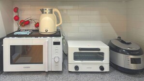 Eine Küche mit einem Cuckoo-Ofen, einem Jenniferoom-Toaster und einer Cuchero-Kaffeemaschine auf einer Arbeitsplatte.