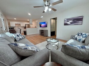 A modern living room with a grey sofa set, a glass coffee table, and a ceiling fan. - 3Min To Parris Island. Pets Yes (Port Royal)