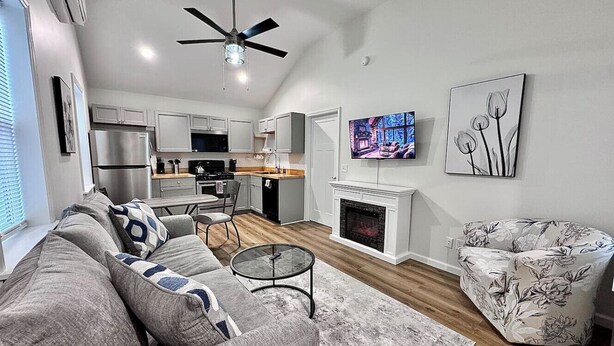 A modern living room with a grey sofa, a round coffee table, and a fireplace.