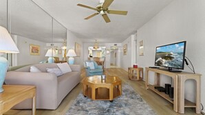 A spacious living room with a sofa, coffee table, and TV stand.