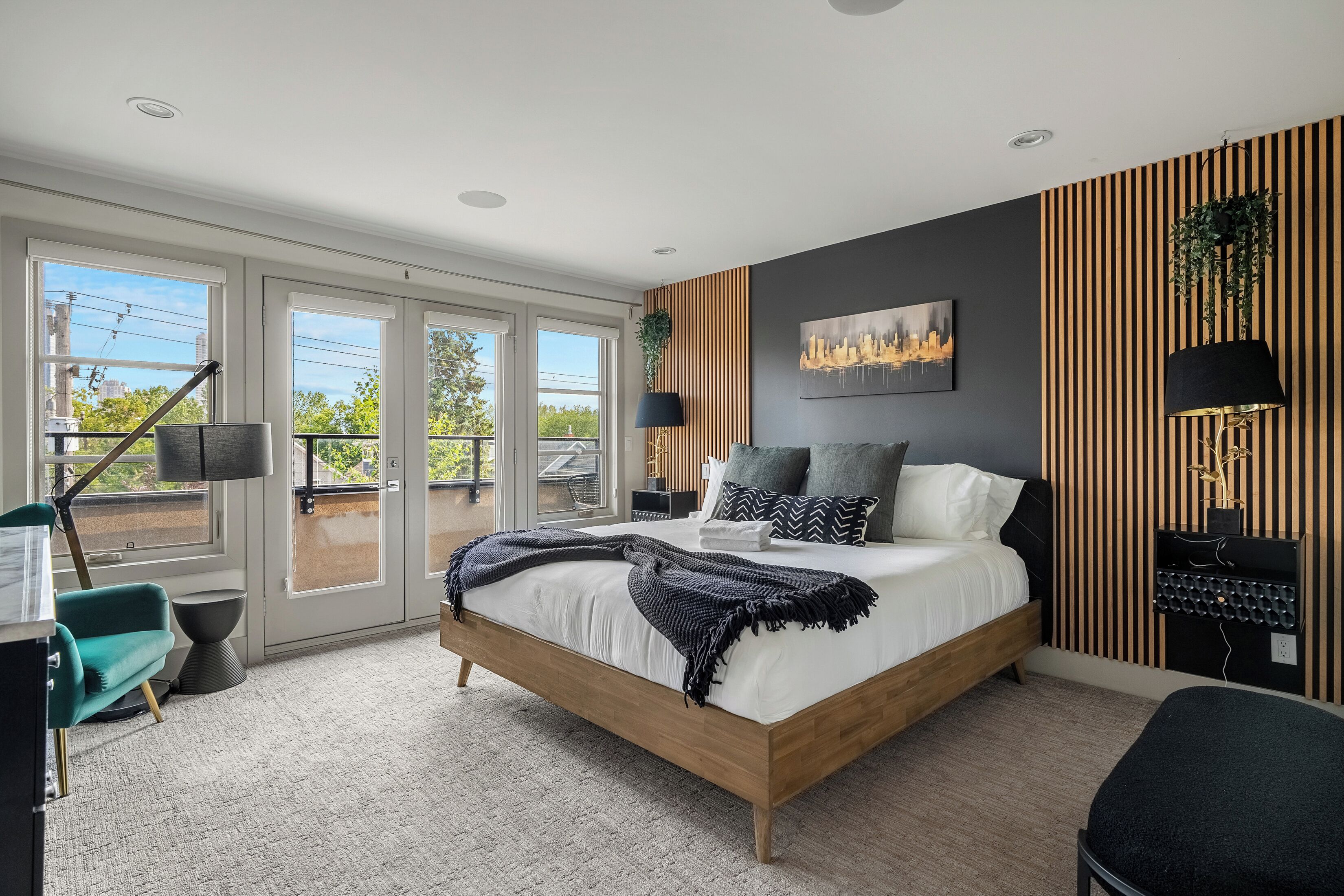 A modern bedroom with a large bed, a desk, and a chair.