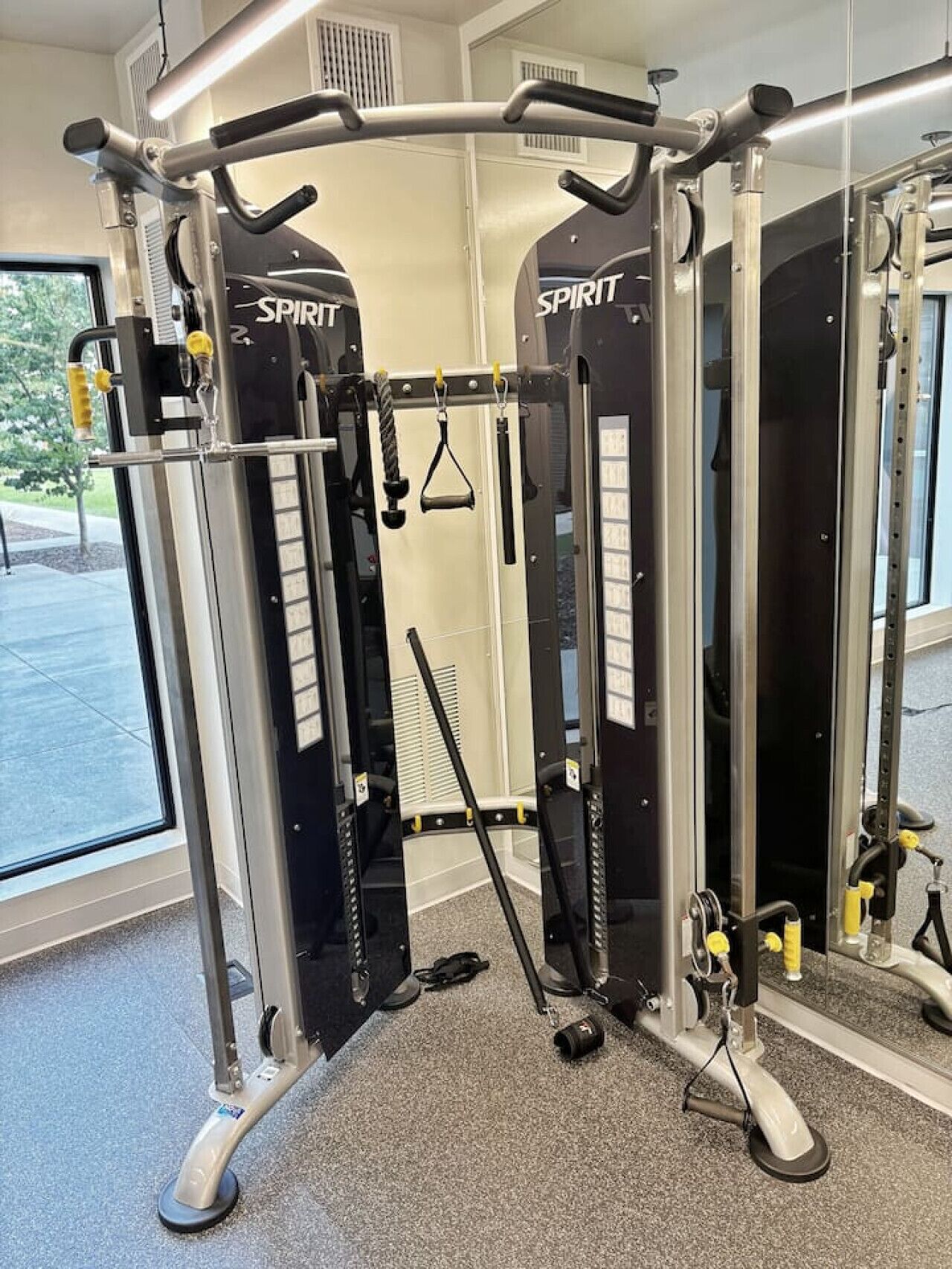 A gym with a multi-functional workout machine labeled 'SPIRIT'.