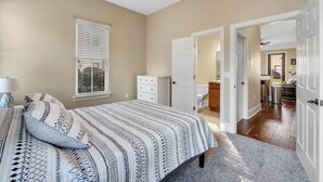A bedroom with a bed, a dresser, a window with blinds, and a ceiling fan. - Midtown Home, Pets Welcome! (Tallahassee)