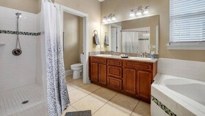 A bathroom with a shower, toilet, double sink vanity, and a bathtub. - Midtown Home, Pets Welcome! (Tallahassee)