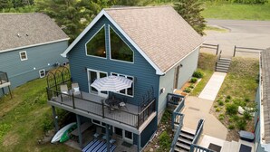 A two-story house with a balcony, a deck, and a garage. - WALDEN HAUS -Lakefront Chalet- Dog Friendly & Breakfast-Golf-Bike-Hike-Swim-Ski (Biwabik)