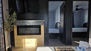 Ein modernes Wohnzimmer mit Kamin, Couchtisch aus Holz und einem Gesellschaftsspiel.