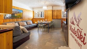 Een gezellige kamer met houten inrichting, een zithoek en uitzicht op de bergen.
