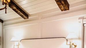 A bed with white linens, a wooden headboard, and two bedside lamps. - The Donna King Suite - Bootleggers Lodge on Lake Nokomis (Tomahawk)