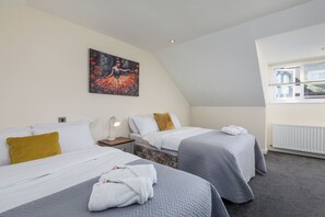 Ein Hotelzimmer mit zwei Betten, einem Bild an der Wand, einem Fenster mit Blick und einer Heizung.