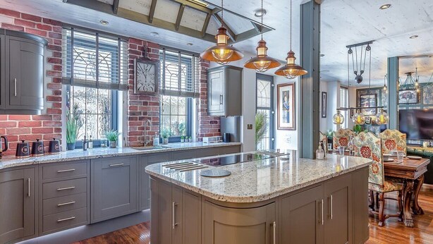 A spacious kitchen with a large island, built-in appliances, and pendant lighting.