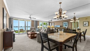 A spacious living area with a large dining table, comfortable seating, and a view of the outdoors.