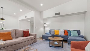Una sala de estar moderna con dos sofás, una mesa de centro y una lámpara de pie.
