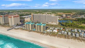 A coastal hotel complex with multiple high-rise buildings, a beach, and a marina.