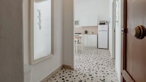 A hallway leading to a kitchen with white cabinets, a microwave, and a coffee maker. - GuestHost - Cozy 87 sqm apartment, for 6 people, located on the first floor of a building (NO lift). The accommodation is located in the heart of the historic Ballarò market (in a restricted traffic zone), an area where it is possible to savor the true  (Palermo)