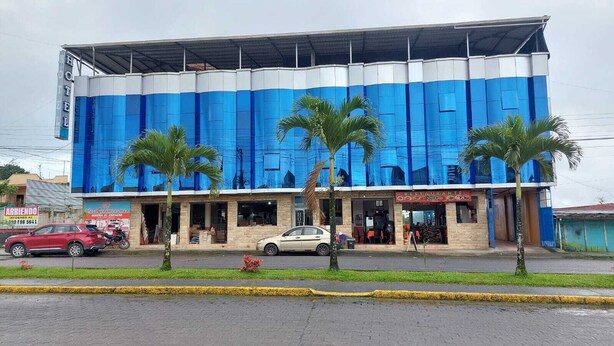 A hotel with a blue facade, a restaurant, and a sign for a moving company. - Hotel Cristal Azul (Pedro Vicente Maldonado)