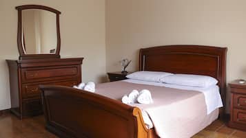 Relax in comfort with a large bed, dresser, and mirror in this well-appointed room.