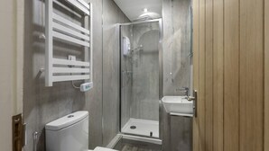 A modern bathroom with a glass shower enclosure, a toilet, and a sink. - 1 Bedroom bolthole in Seahouses (Seahouses)