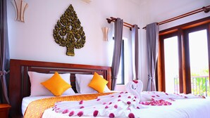 Une chambre d’hôtel avec un grand lit, un élément décoratif mural et un balcon avec des rideaux.