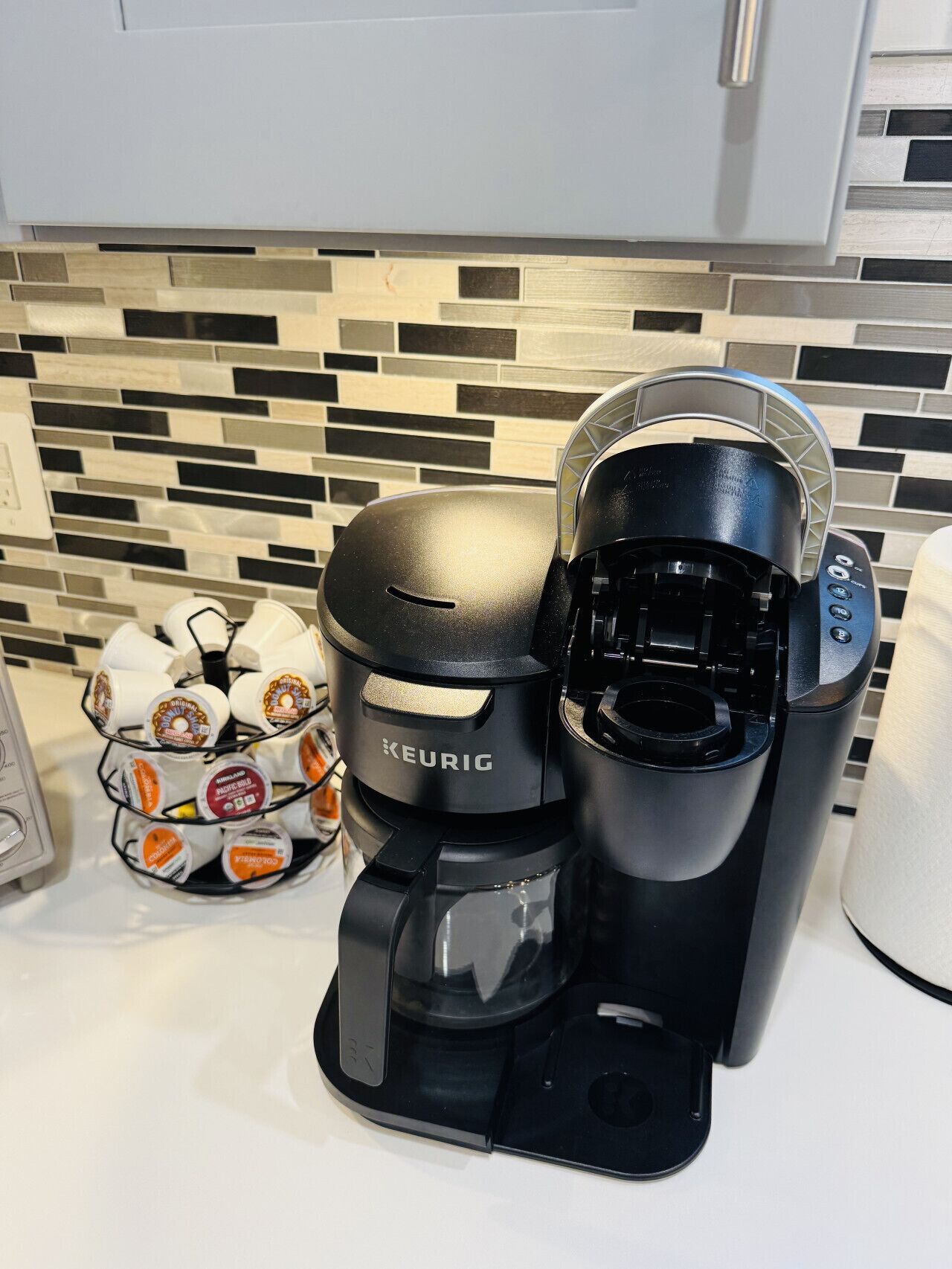 Una cafetera Keurig con un soporte para cápsulas de café sobre una encimera de cocina.