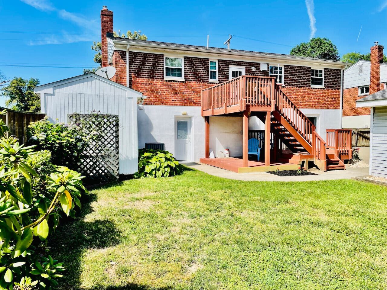 A two-story house with a wooden deck and a garage.