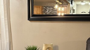 Una pequeña mesa de madera con una planta en maceta y un florero decorativo.