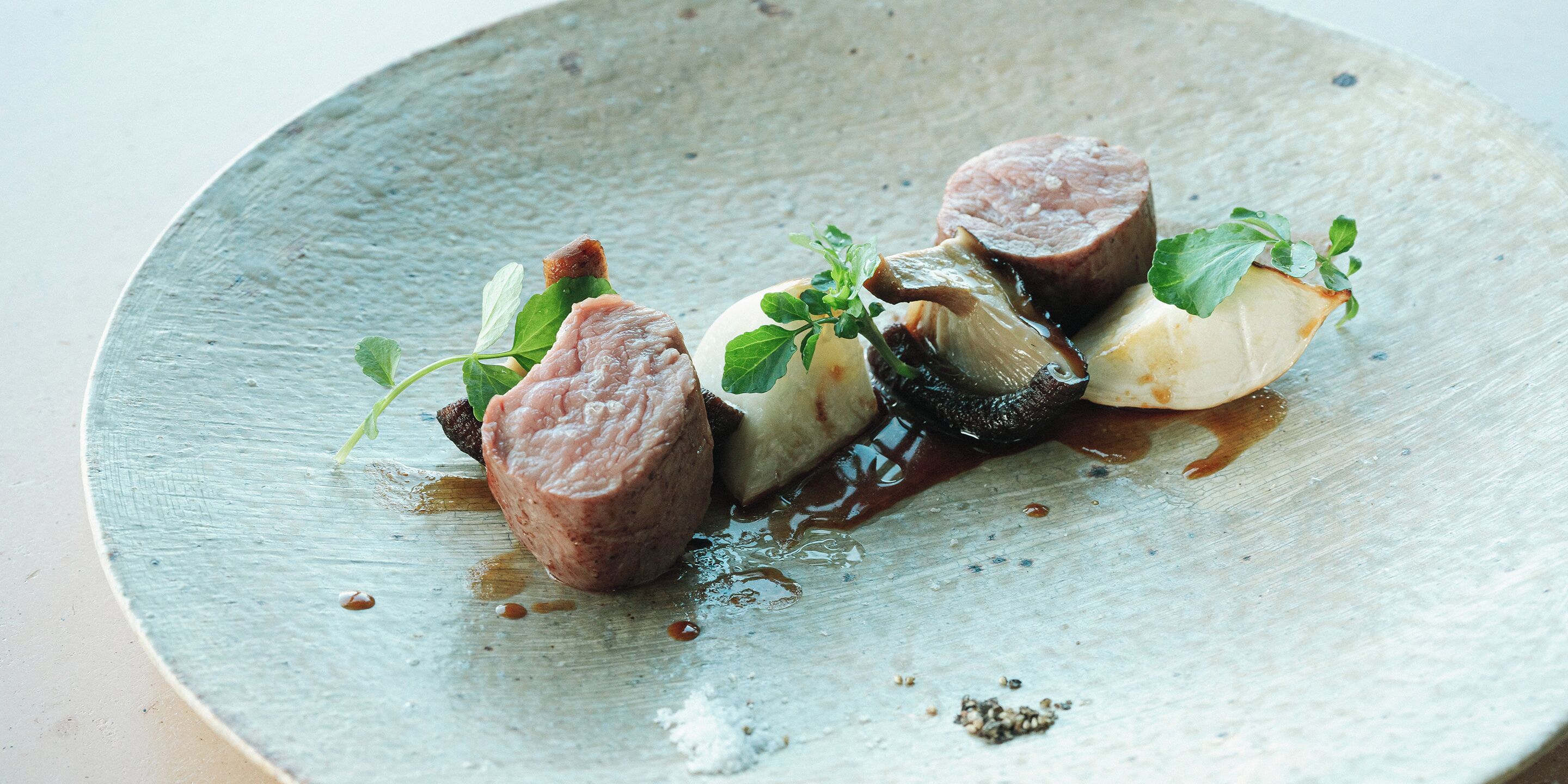A plate with food items including meat, vegetables, and a sauce.