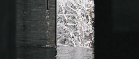 Una ventana con vistas a árboles cubiertos de nieve.