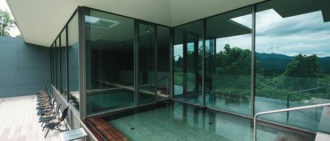 A modern interior with a glass wall offering a view of a mountainous landscape.