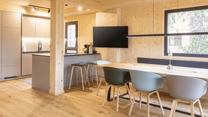 Una cocina moderna con armarios de madera, una isla central y taburetes de bar.