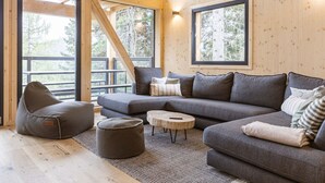 Un intérieur moderne avec un canapé d’angle, un fauteuil en forme de poire et une petite table basse.