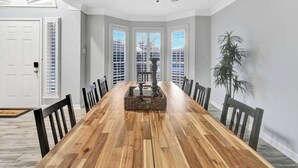A dining room with a wooden table, chairs, a ceiling fan, and a view through the windows. - Heated Pool and Hot tub in Rowlett/Game Room/Near Lakes (Rowlett)