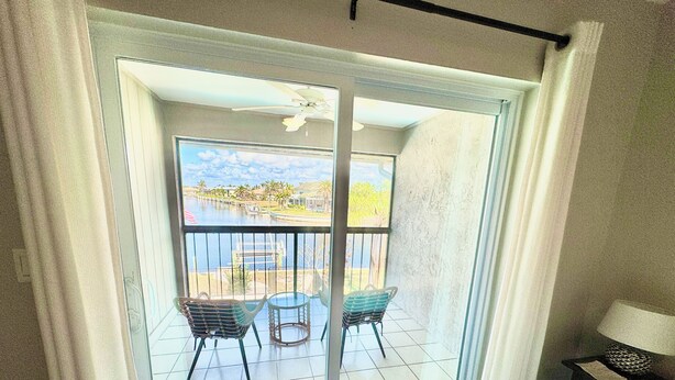 A balcony with a view of a body of water, two chairs, and a table. - Punta Breeze 2-bedroom townhome, pool, boat dock & WiFi in relaxing Punta Gorda (Punta Gorda)