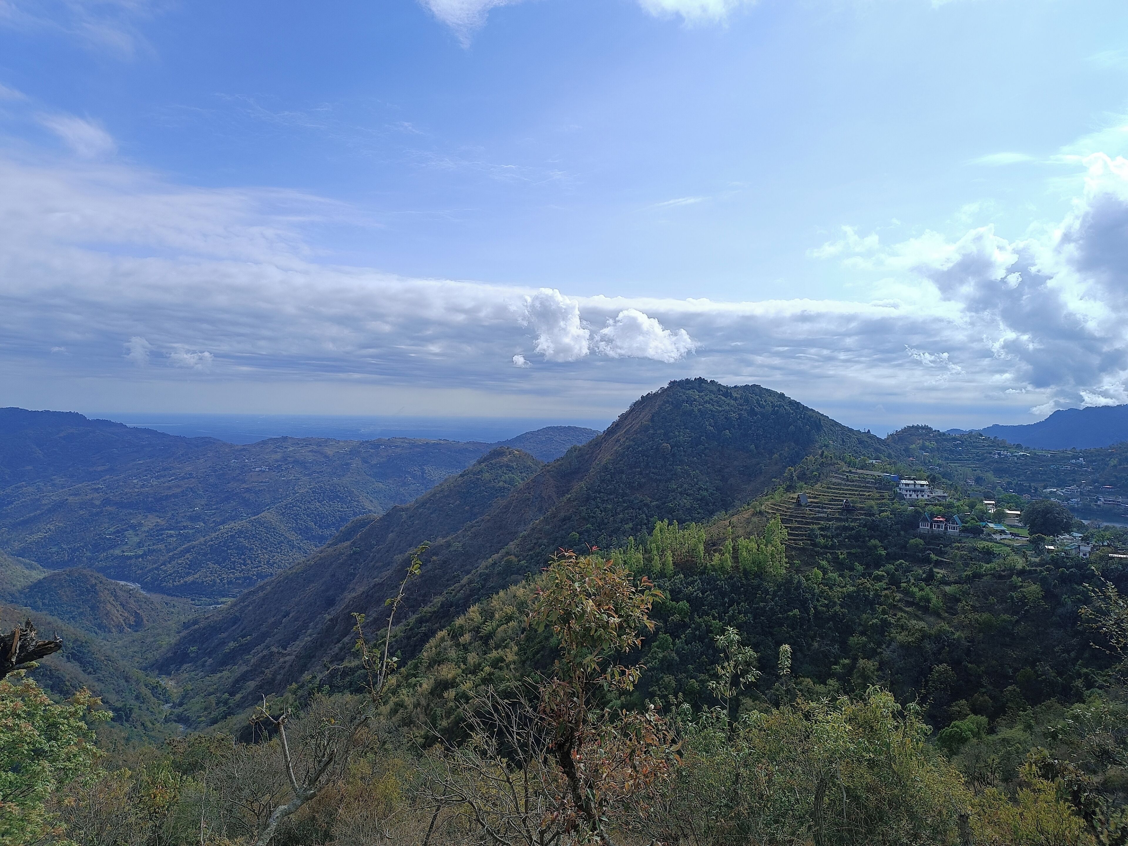 A mountainous landscape with terraced fields and scattered buildings.