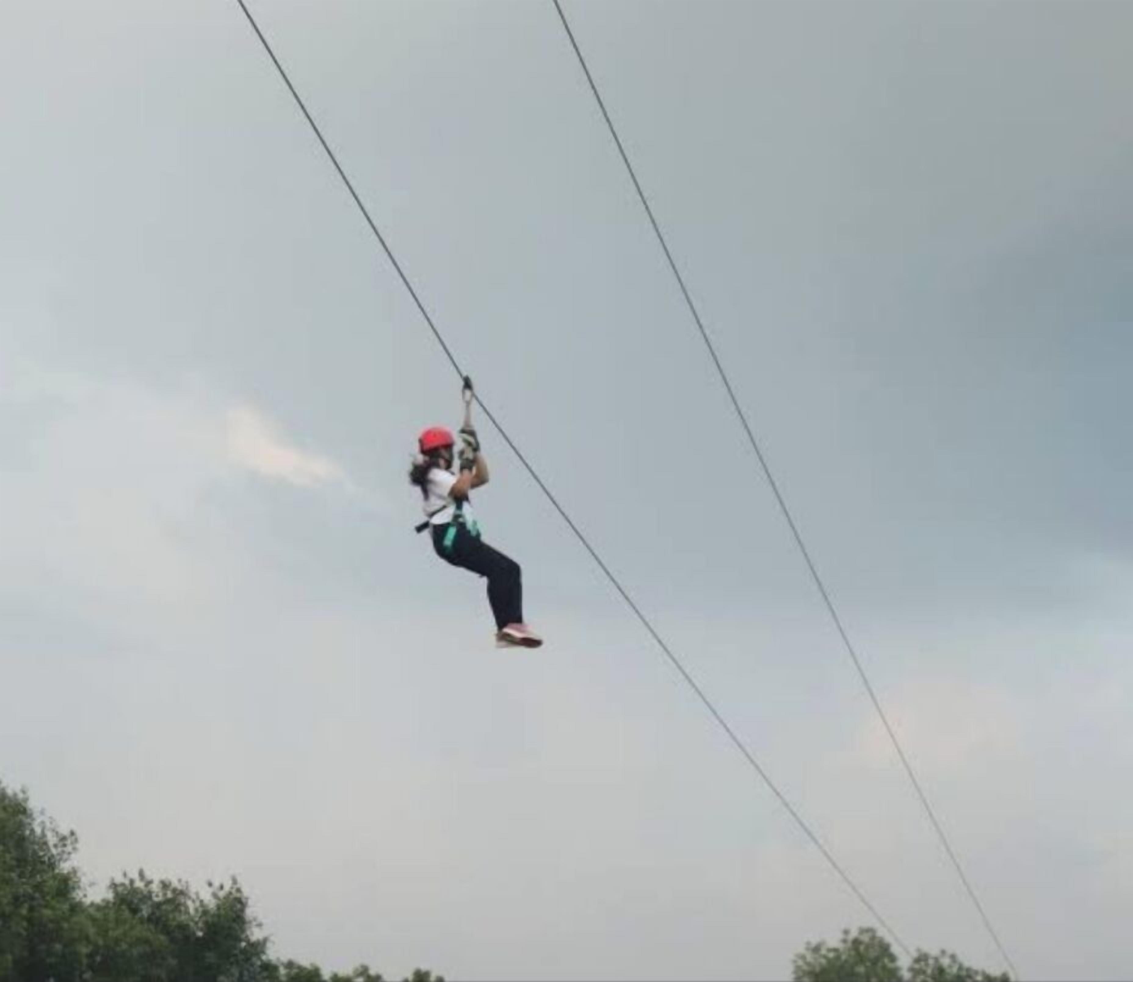 A person zip-lining in the air.