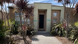 A building entrance with a brick facade, a door, and a sign reading "Seclusion." - Searenity only 750 m to the beach, pet friendly (St Leonards)