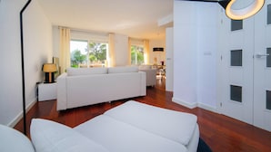 Ein modernes Hotelzimmer mit einem großen Bett, einer Couch und einem Essbereich.