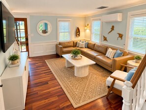 A living room with a sofa, coffee table, and a television.