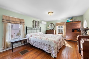Une chambre à coucher avec un lit, une commode et un bureau avec une lampe.