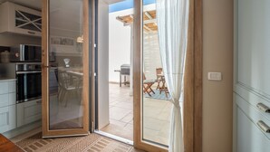 A kitchen with a sliding glass door leading to an outdoor patio area. - Villa Olga in exclusive setting with private access to Nora beach (Pula)