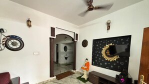 Un soggiorno con televisore, una statua e una ventola a soffitto.