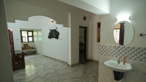 Un bagno con lavandino, specchio e pavimento piastrellato.