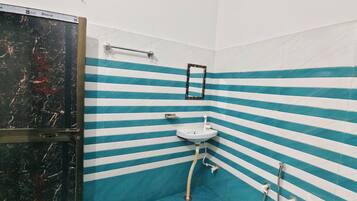 Une salle de bain avec des murs à rayures, un lavabo, un miroir et une douche.